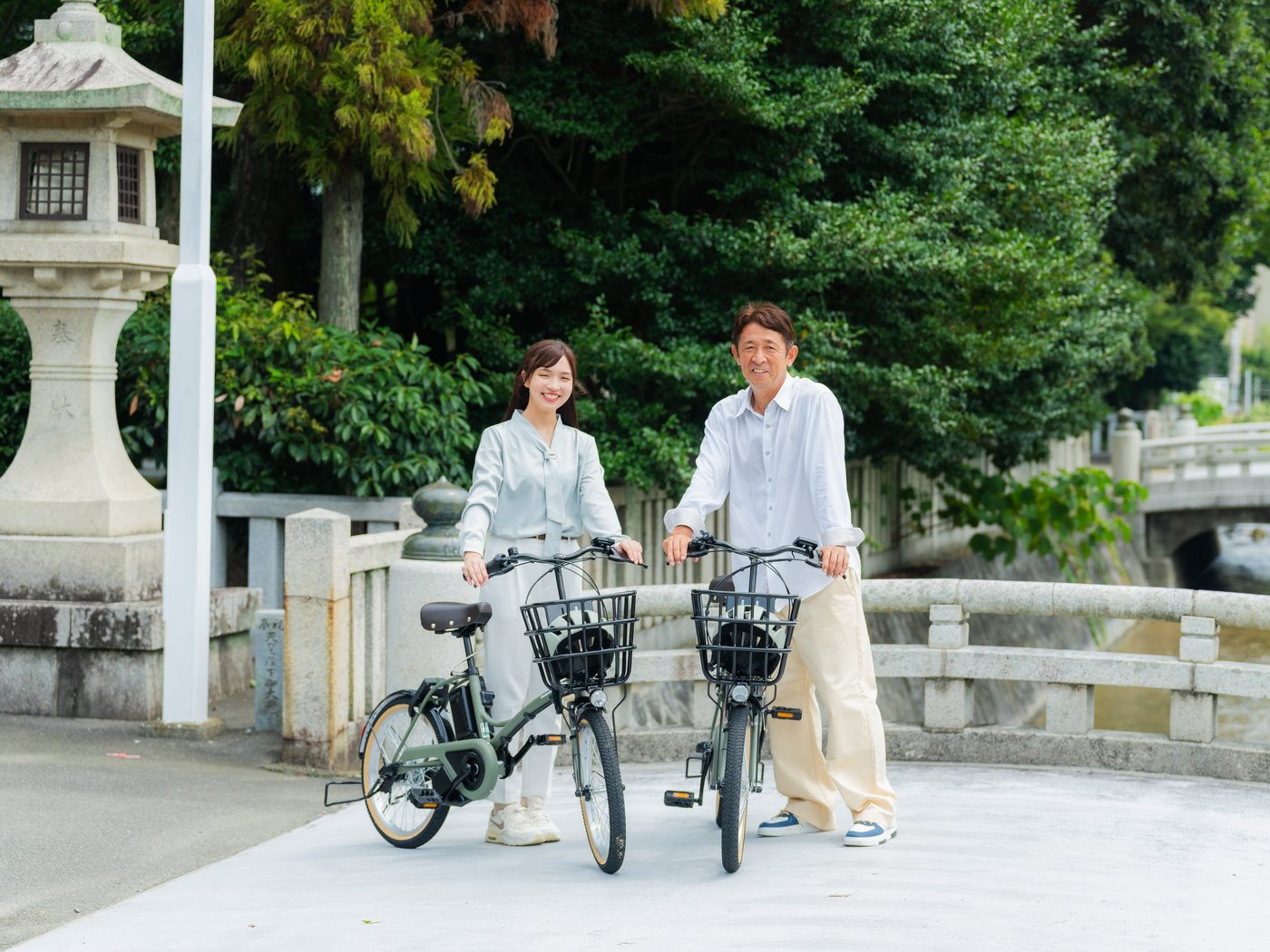 橋の上で自転車を押して歩く2人の利用者
